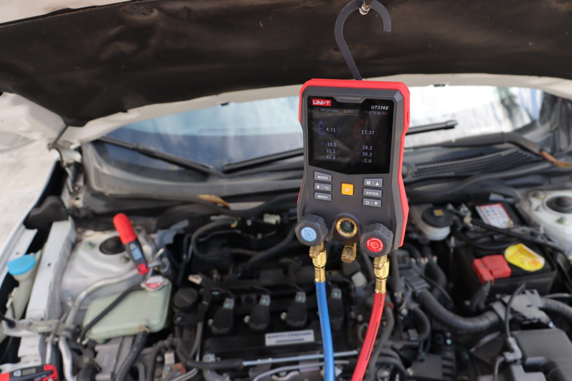 Digital manifold gauge UT336E KIT hooked in an engine bay for automotive AC maintenance