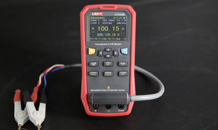 UNI-T UT622E LCR meter in use, performing a precise resistance measurement with the included Kelvin test leads to eliminate errors.