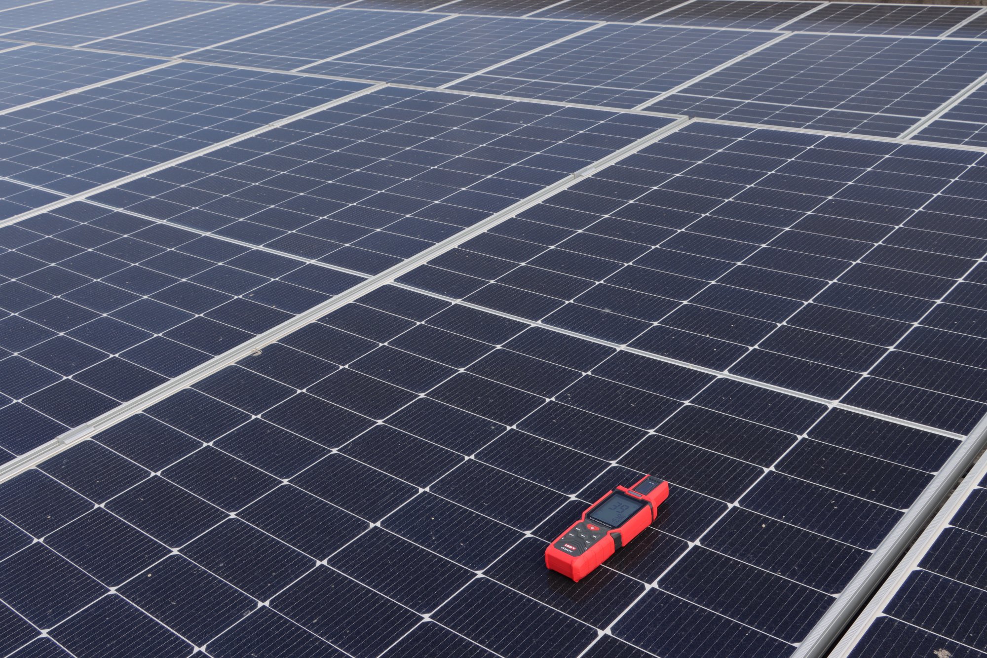 Photovoltaikanlage mit aufgelegtem UNI-T UT381PV Einstrahlungsmessgerät in der Totalen