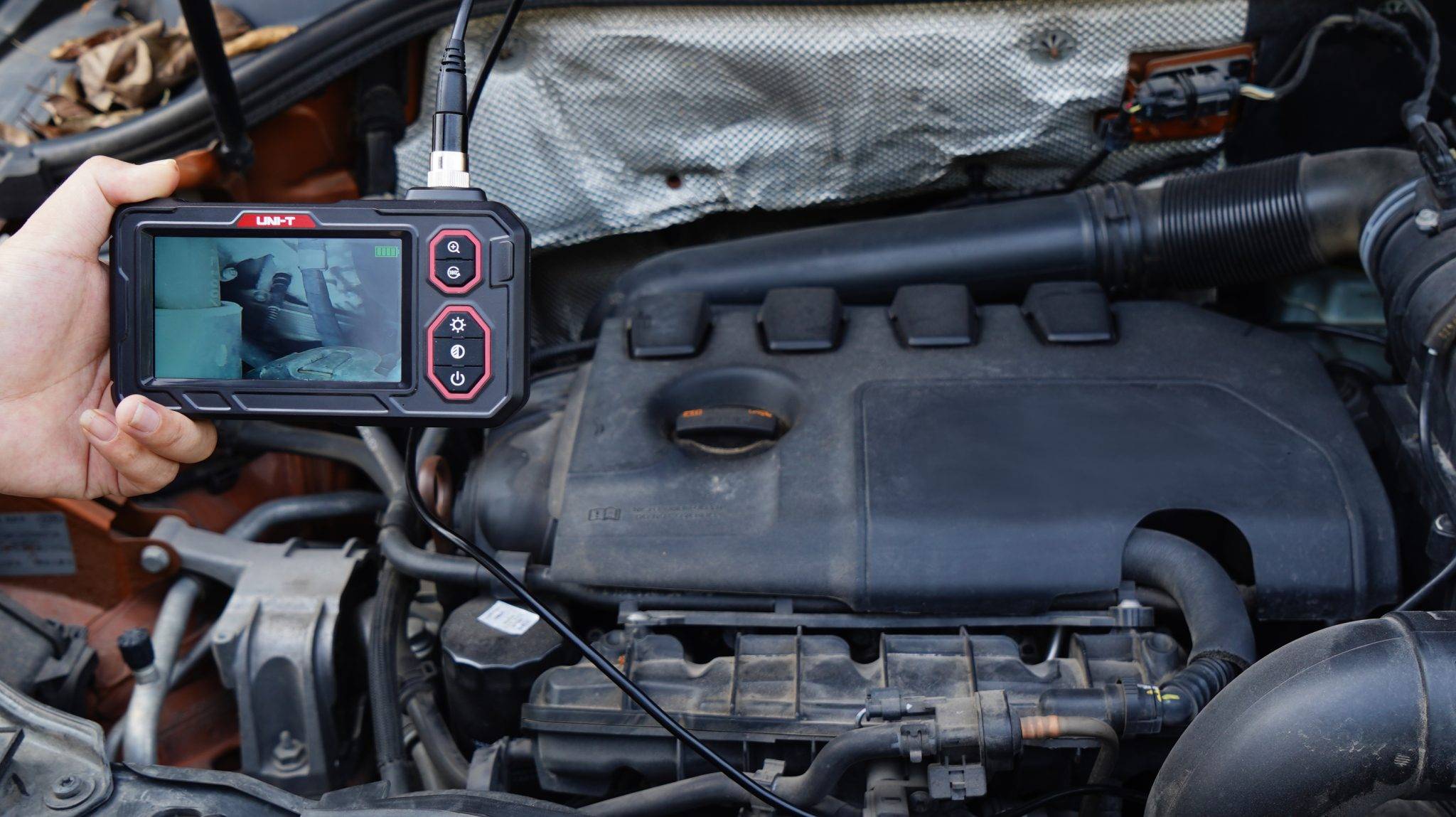 Ein Techniker verwendet das UNI-T UT667-5m Endoskop, um den Motorraum eines Autos auf Schäden zu überprüfen.
