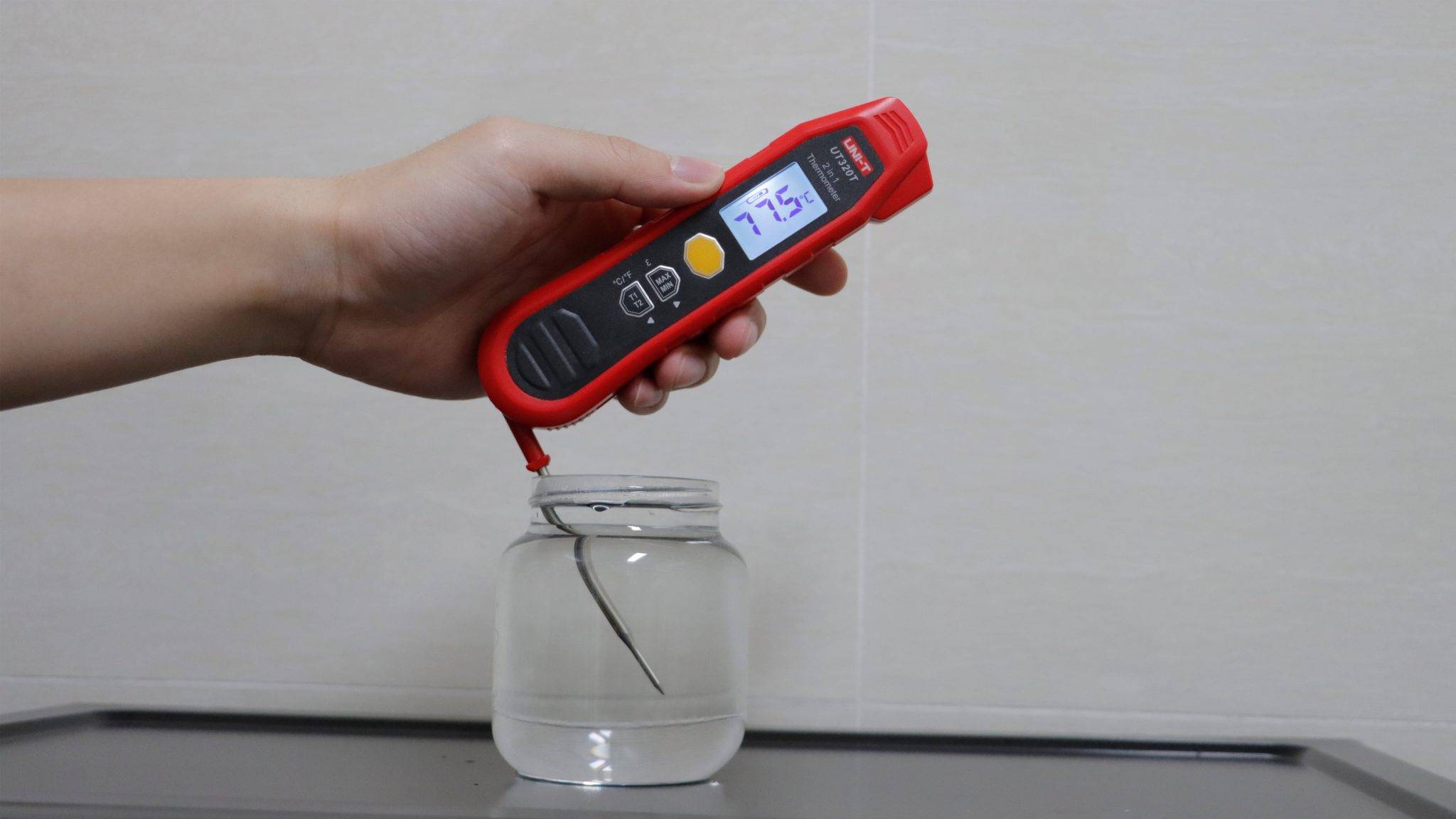 Messung der Flüssigkeitstemperatur mit dem ausklappbaren Einstichfühler des UNI-T UT320T Thermometers.