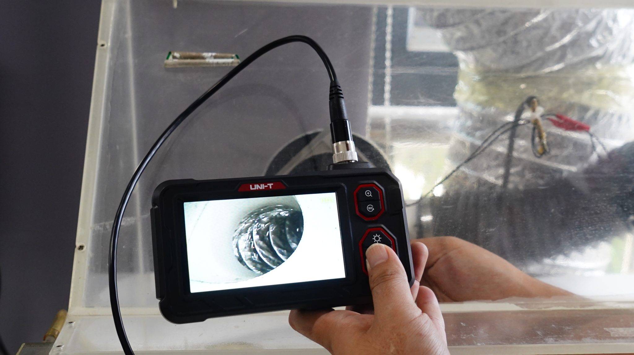 Rohrinspektion mit dem UNI-T UT667 Endoskop, das Display zeigt das Innere eines gewundenen Rohrs.