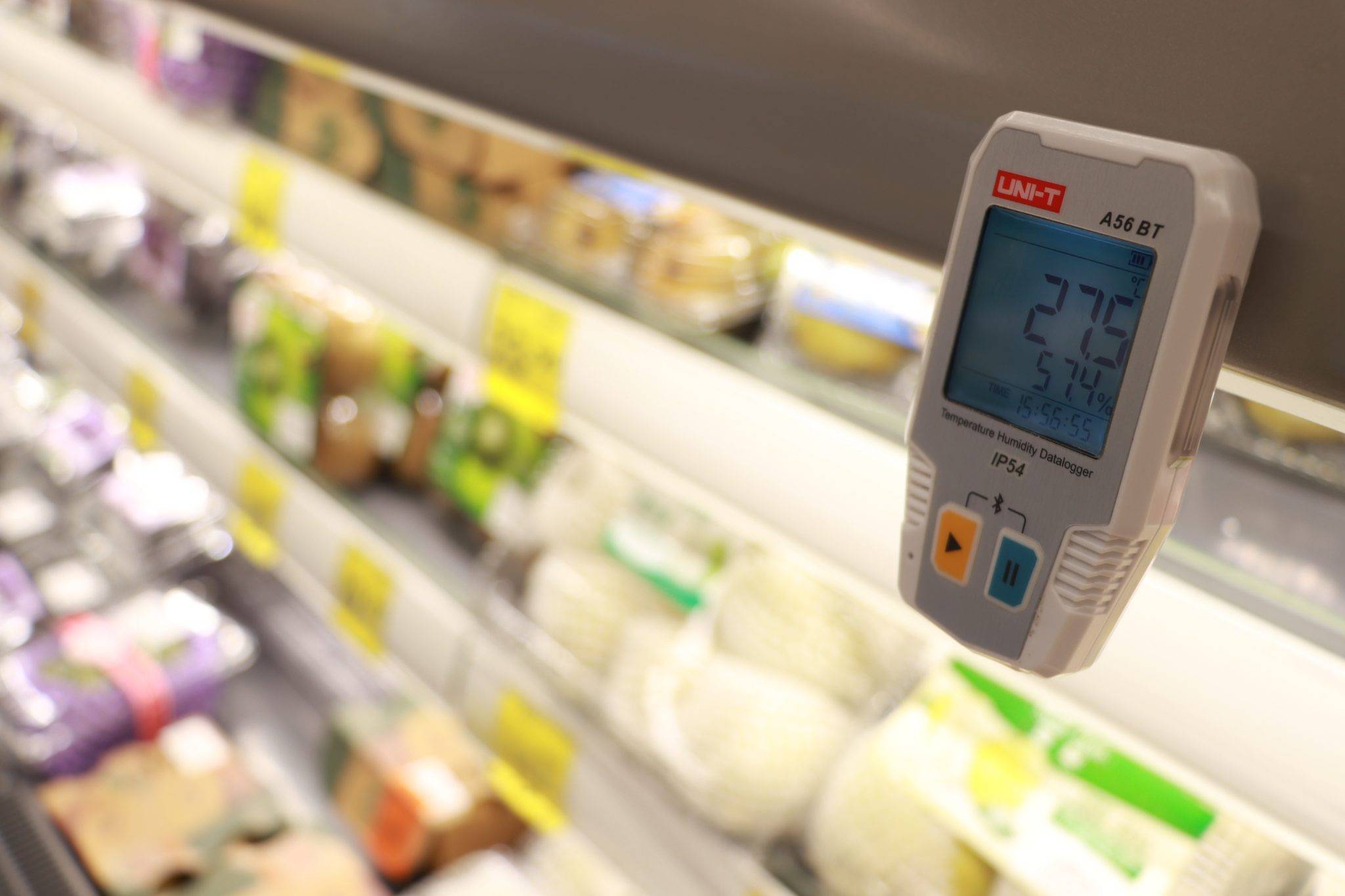 UNI-T A56 BT im Einsatz zur Überwachung der Kühlkette in einem Supermarkt-Kühlregal mit Gemüse.