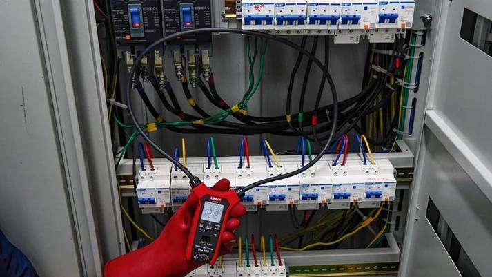 Einsatz der UNI-T UT281F Flexzange in einem Schaltschrank, die flexible Spule umschließt ein Bündel von Kabeln an Sicherungsautomaten.